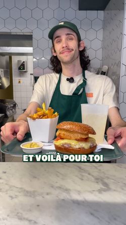 Un serveur présente un burger, des frites et une boisson au bar de Bioburger Metz Saint Jacques.