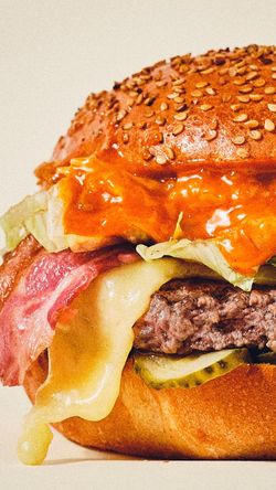 Burger bio avec pain aux graines, fromage, bacon, salade et sauce orange au restaurant Bioburger Bordeaux Belcier.