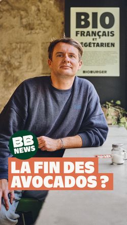 Personne assise dans un restaurant burger bio Bioburger Angers Foch avec panneau "Bio Français et Végétarien" visible.
