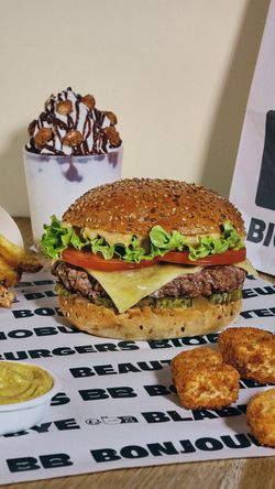 Savoureux burger avec fromage, tomate, laitue, servi avec des accompagnements et dessert au restaurant bio.