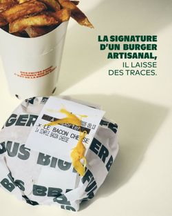 Burger artisanal emballé avec étiquette et frites croustillantes servies dans un gobelet en carton.