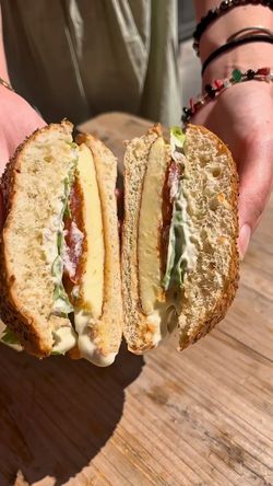 Un sandwich coupé en deux, garni de laitue, d'une tranche de pomme et d'une sauce crémeuse.