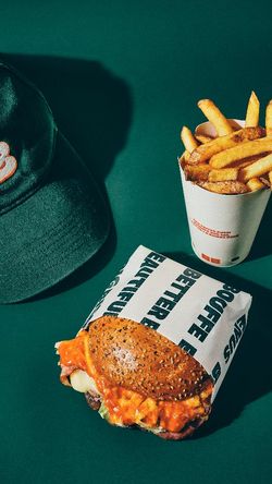 Un burger bio avec des frites sur un fond vert, mettant en avant la cuisine saine de Bioburger Lyon Opéra.