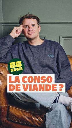 Homme assis sur un canapé en cuir dans un restaurant, portant un sweat-shirt bleu et un pantalon clair.