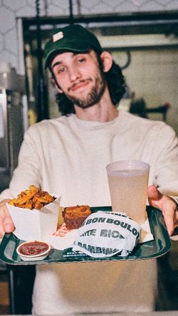 Repas servi comprenant un burger bio, frites, boisson et dessert dans un cadre chaleureux.