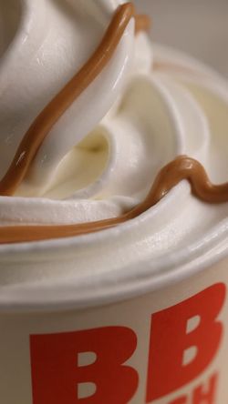 Crème glacée onctueuse, garnie de nappe au chocolat dans un contenant au logo de Bioburger.