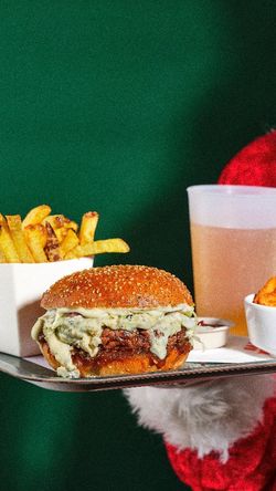 Burger bio garni de sauce, accompagné de frites dorées et d'une boisson. À découvrir au Bioburger Lille Bethune.