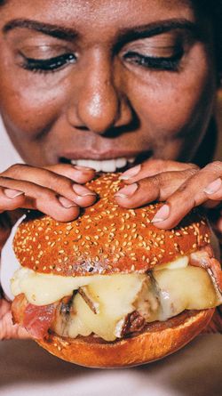 Savourez un hamburger bio fait maison avec du pain au sésame, fromage fondant et garnitures fraîches.