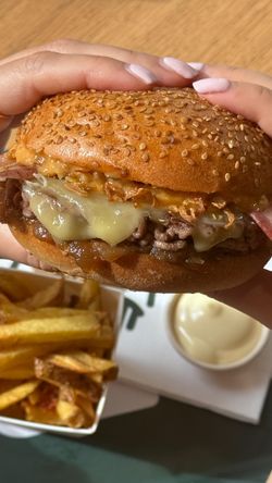 Burger bio au fromage fondu et oignons croustillants, accompagné de frites et sauce mayonnaise chez Bioburger Victoire.