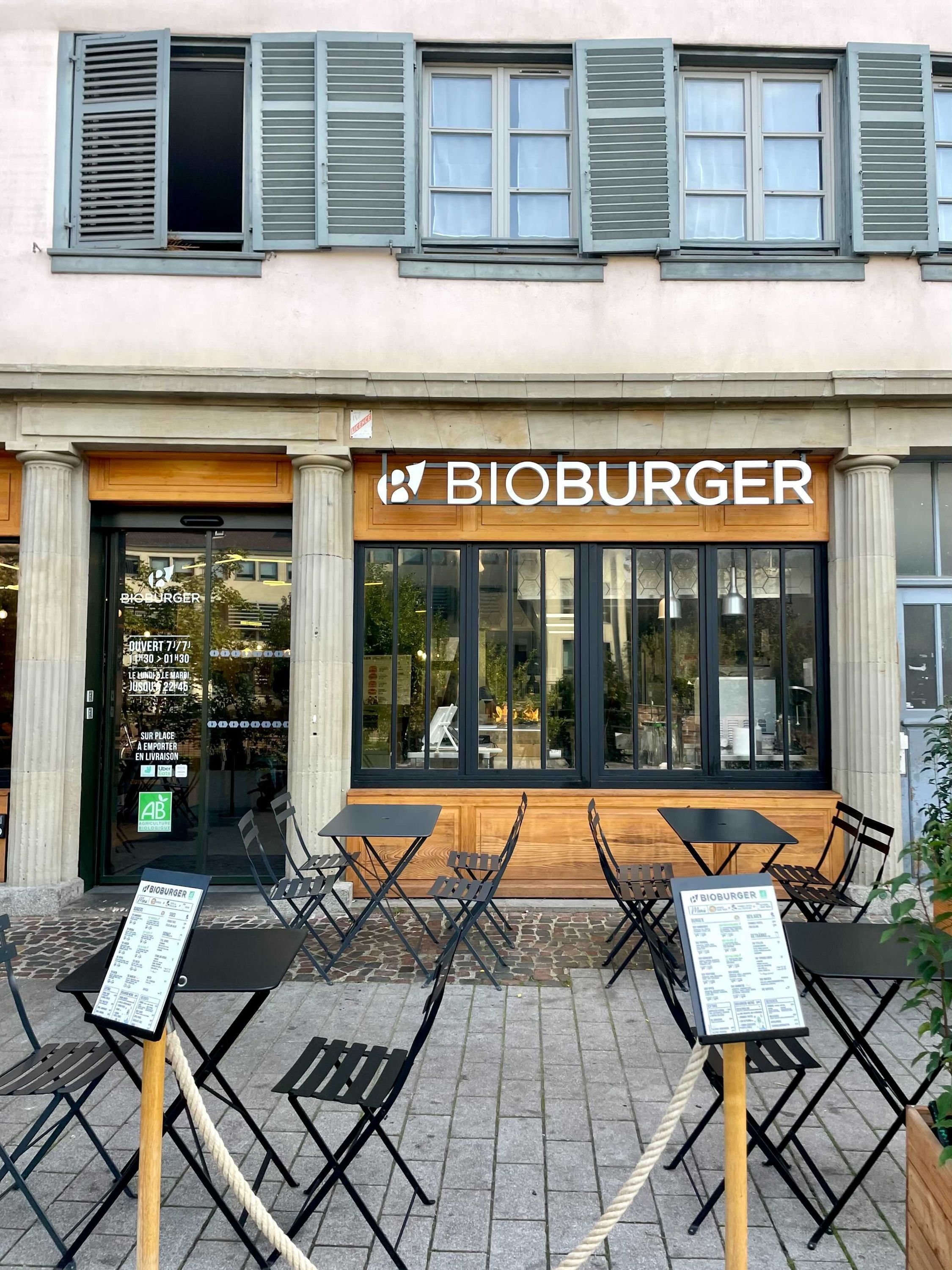 Devanture de Bioburger avec des tables et chaises extérieures. Restaurant bio, proposant burgers végétariens et végan.
