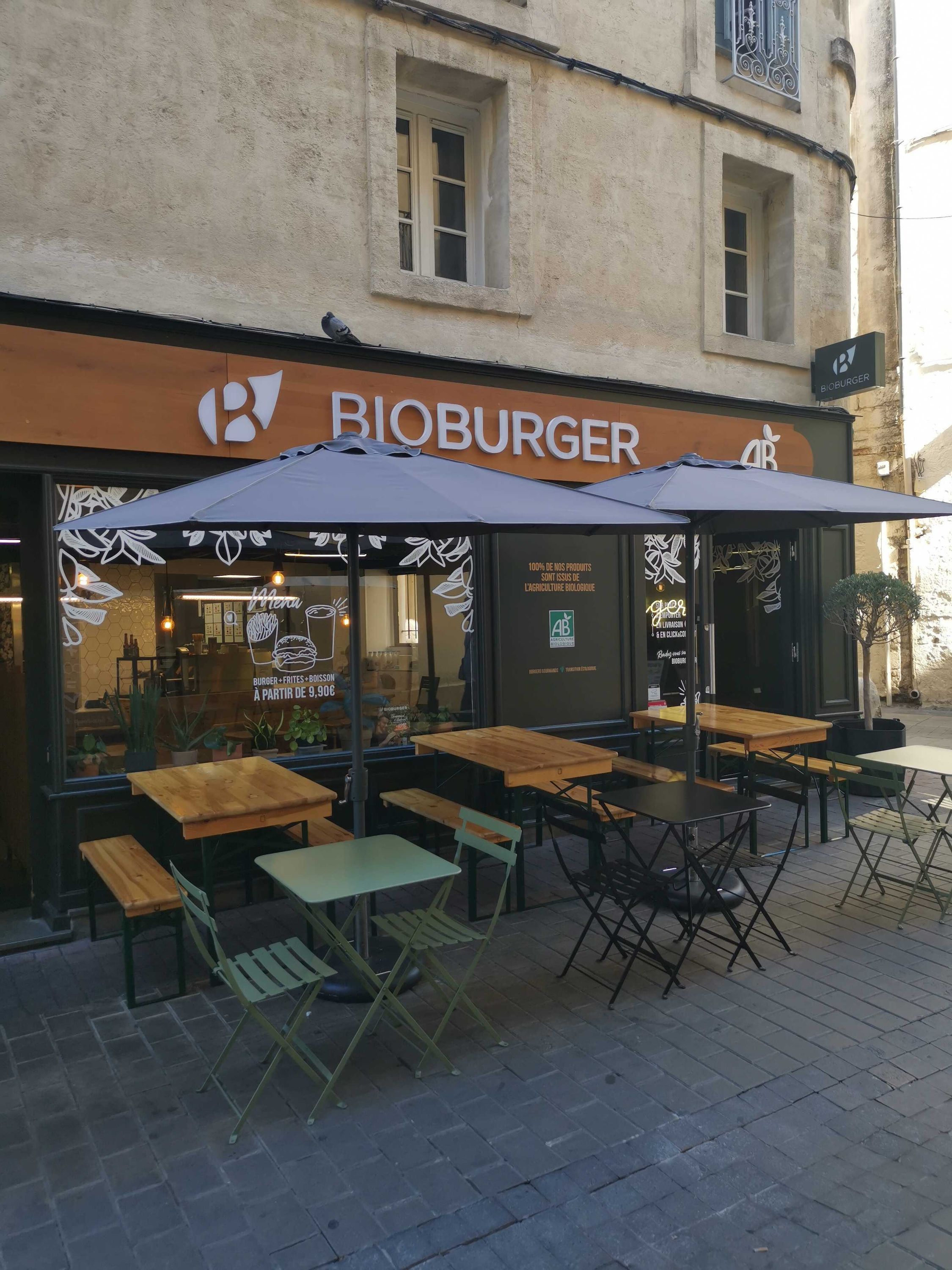 Terrasse de Bioburger Montpellier avec des tables et chaises, mettant en avant des options bio, végan et végétarien.