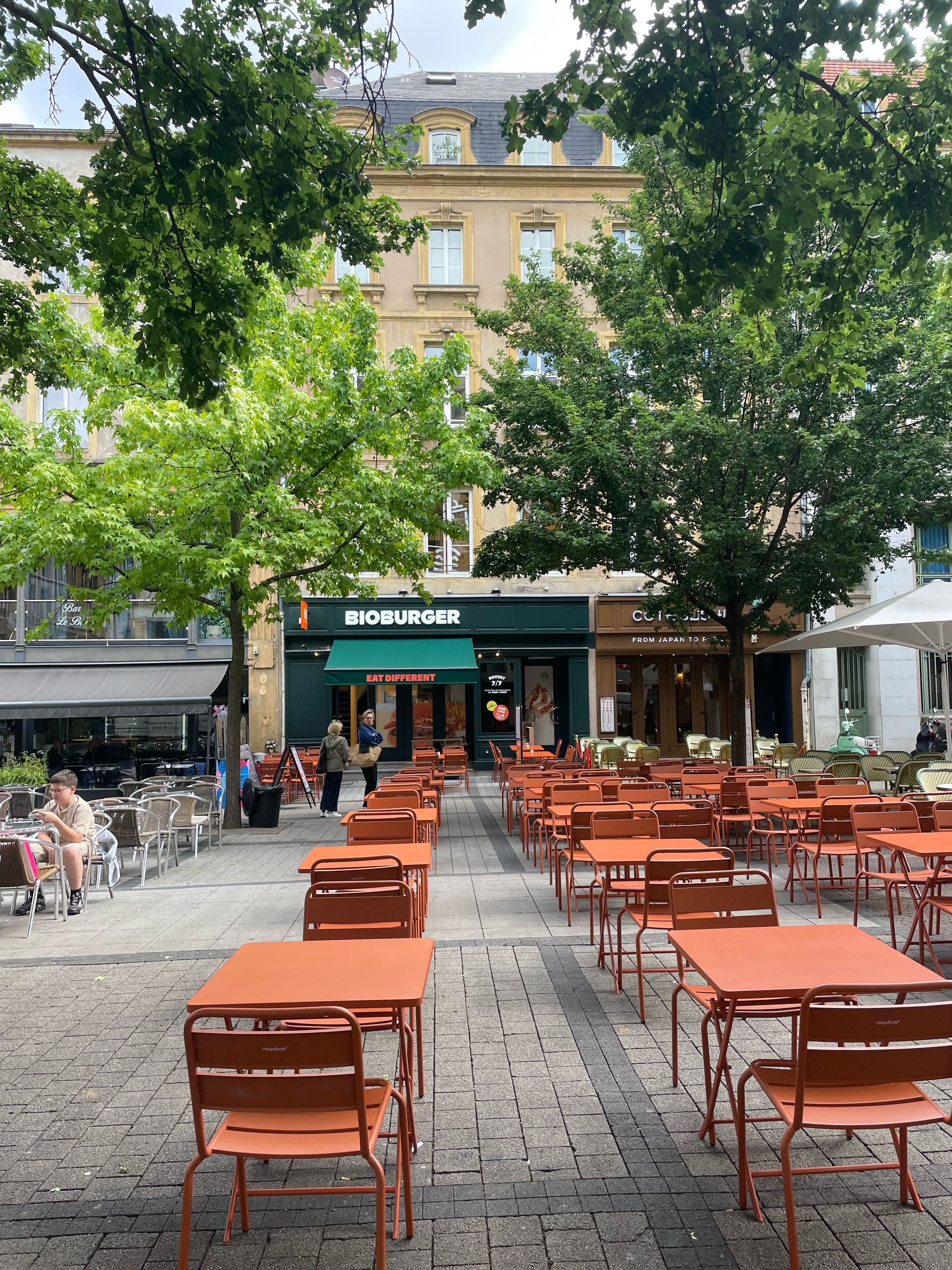 Terrasse du Bioburger Metz Saint Jacques avec tables orange, mettant en avant une ambiance accueillante.