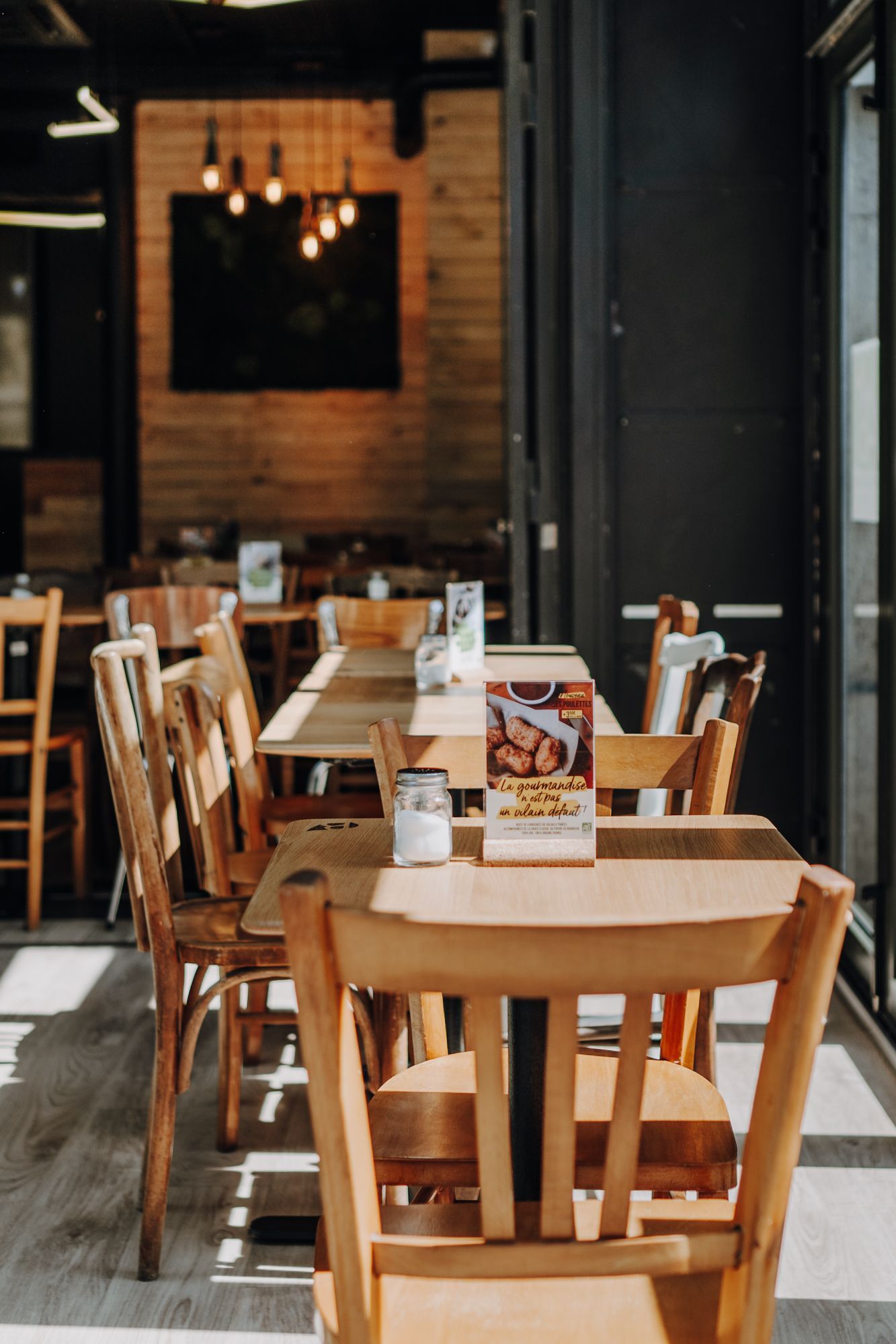 Ambiance intérieure de Bioburger Montparnasse, avec des tables en bois et une décoration moderne.