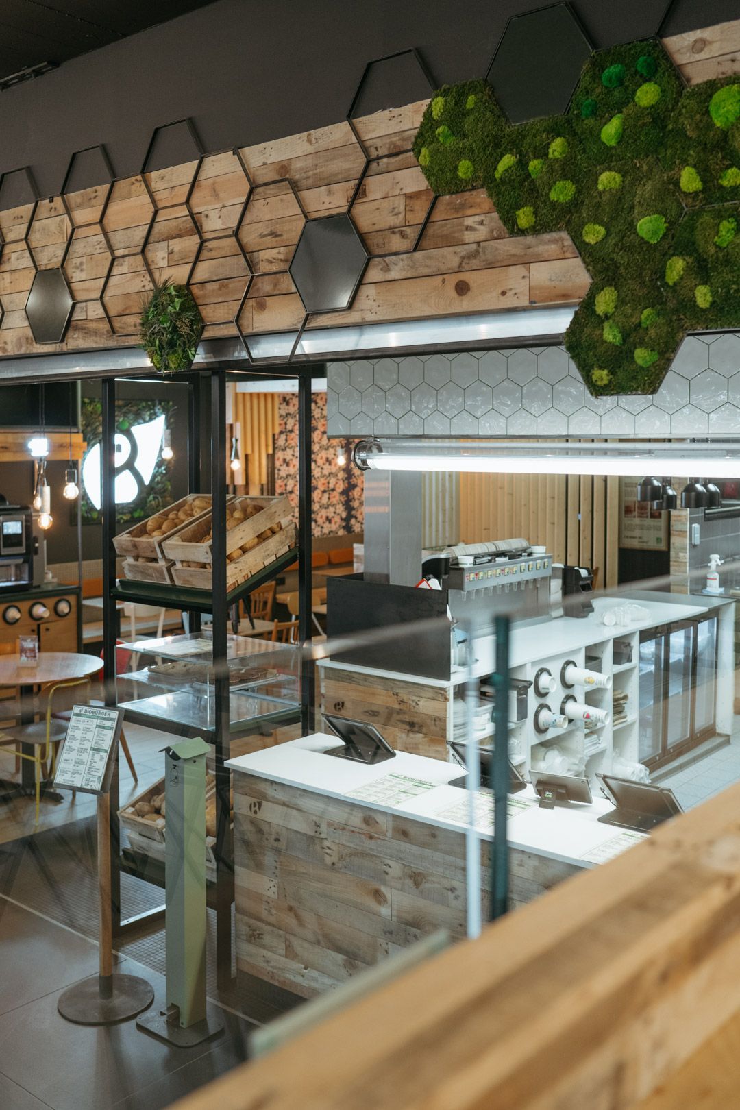 Intérieur du restaurant avec un design rustique, mettant en avant des éléments écologiques et un espace de préparation.