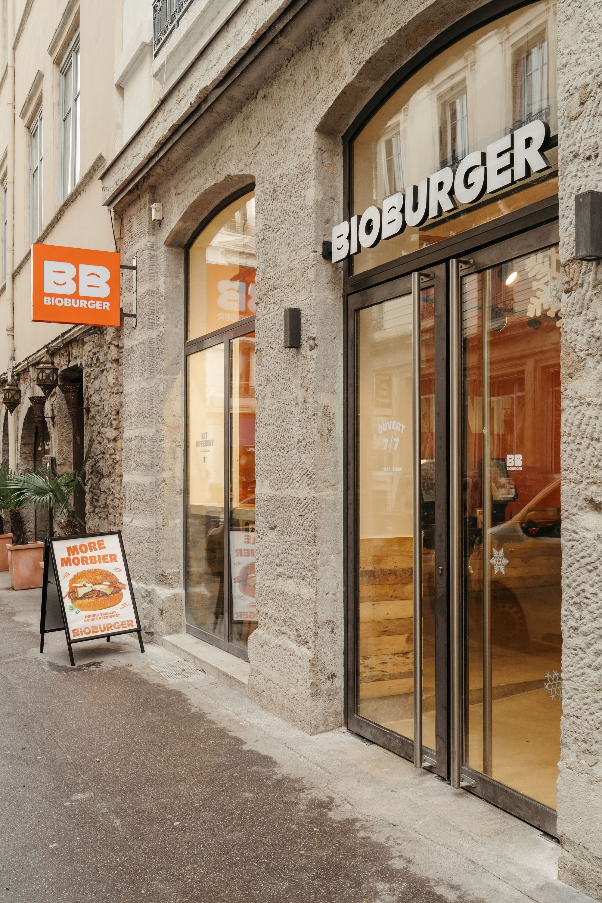 Entrée du restaurant Bioburger Lyon Opéra, avec une enseigne visible et un panneau promotionnel.