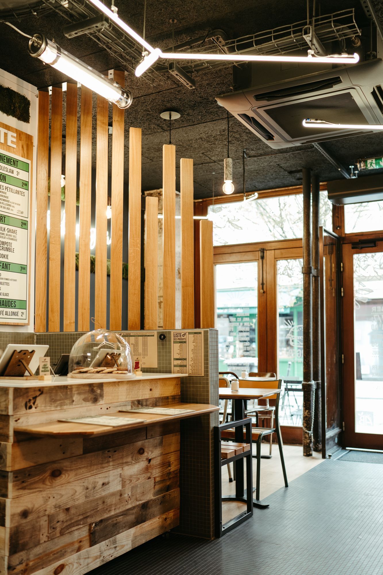 Salle à manger au Bioburger Le Marais, avec une décoration en bois et un coin de commande.