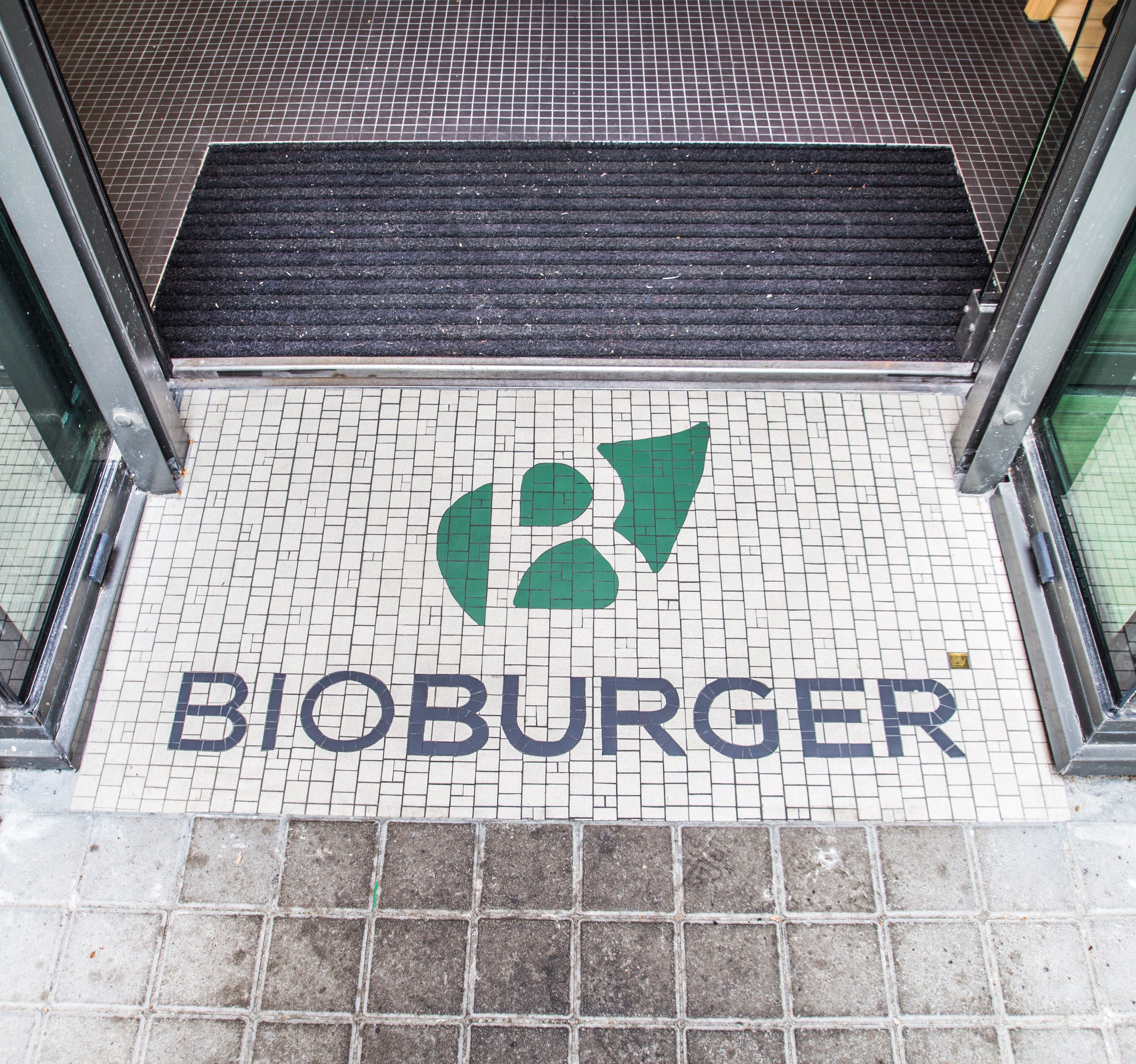 Entrée du restaurant Bioburger, avec un tapis en mosaïque affichant le nom du restaurant.