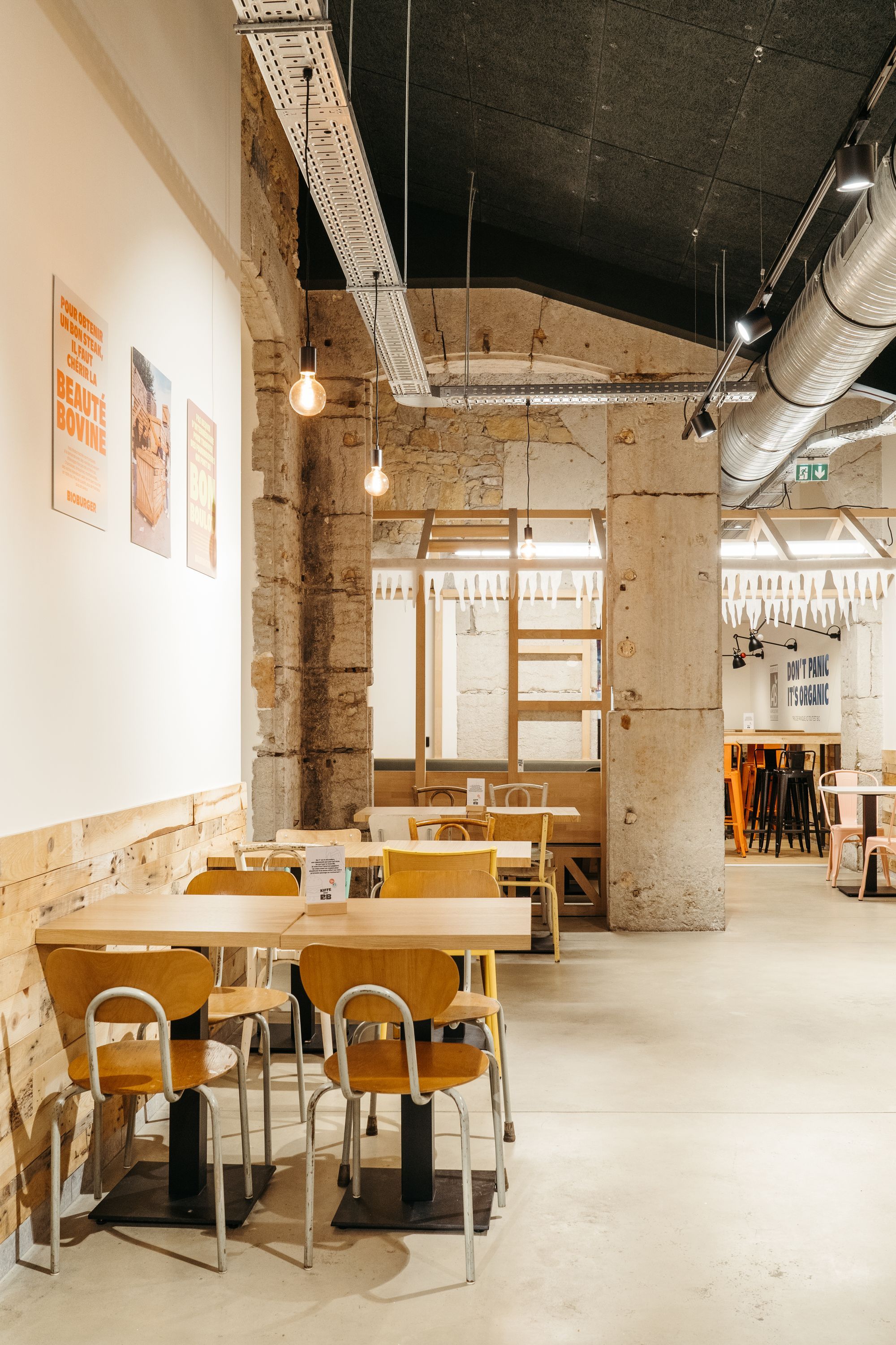 Intérieur du restaurant Bioburger Lyon Opéra avec des tables en bois et une ambiance moderne.