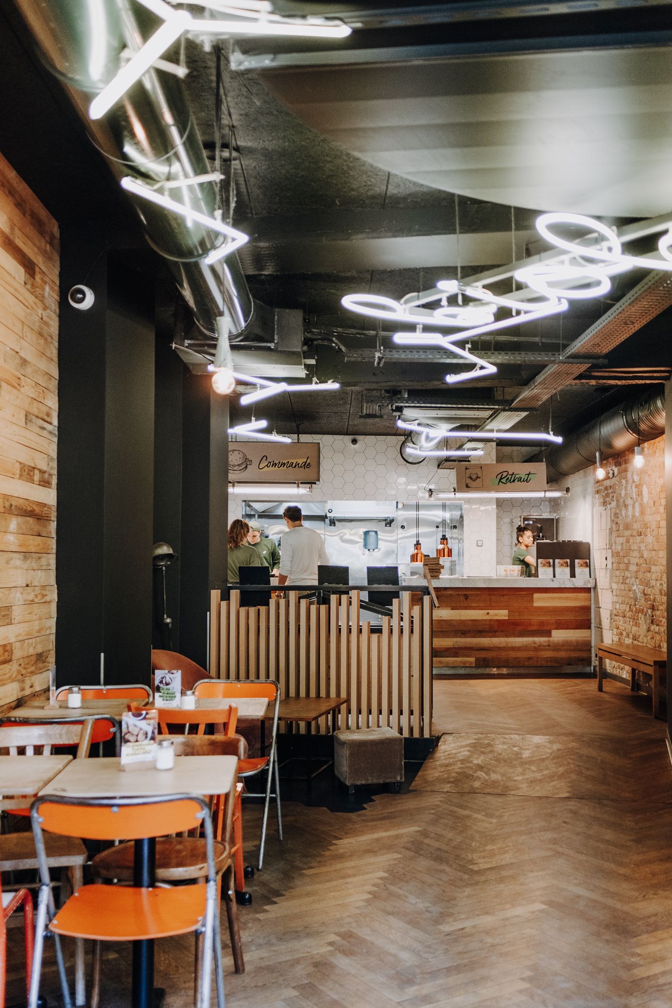 Ambiance moderne du restaurant avec un comptoir et des tables colorées. Un menu axé sur le bio et les burgers.