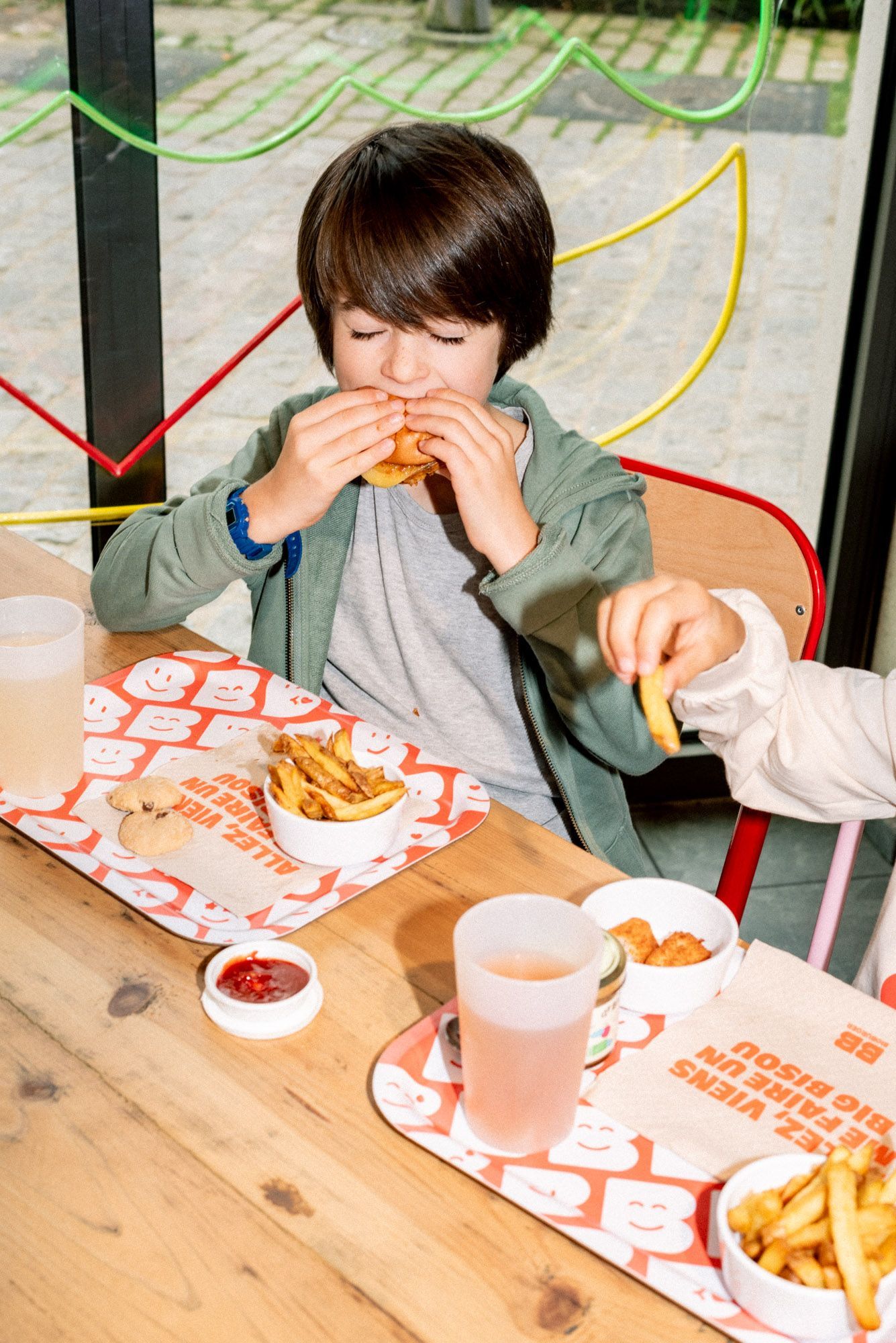 Enfants dégustant des burgers et frites dans un restaurant bio et accueillant pour les familles à Bioburger Toulouse Carmes.