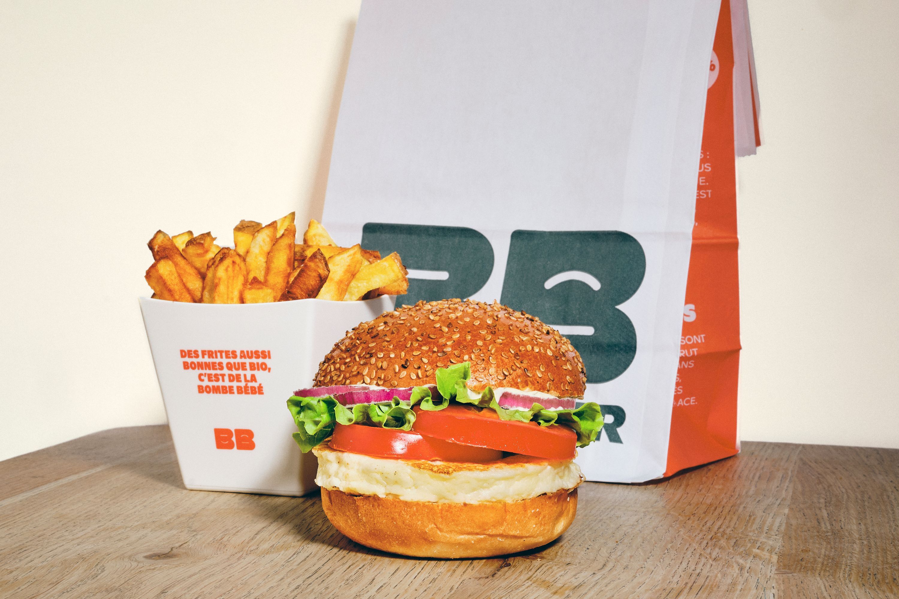 Un burger bio avec des ingrédients frais accompagné de frites dans un emballage du restaurant Bioburger Clermont Jaude.