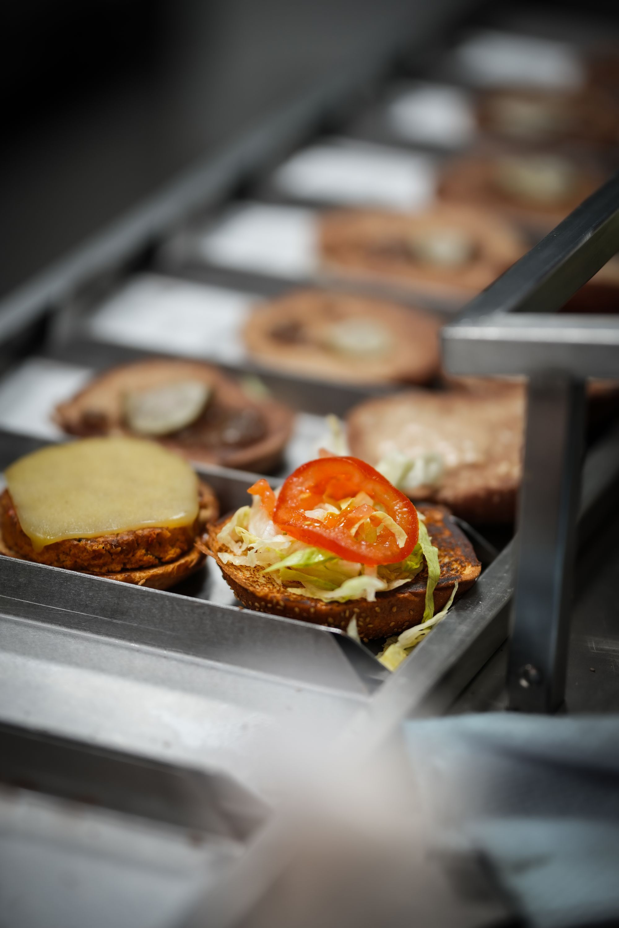 Des burgers bio avec des garnitures fraîches, y compris de la laitue, des tomates et du fromage.