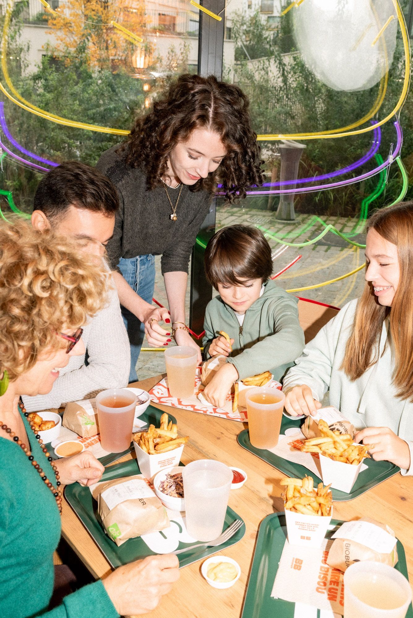 Repas partagé autour de burgers bio et frites au restaurant Bioburger Toulouse Carmes, ambiance conviviale et familiale.
