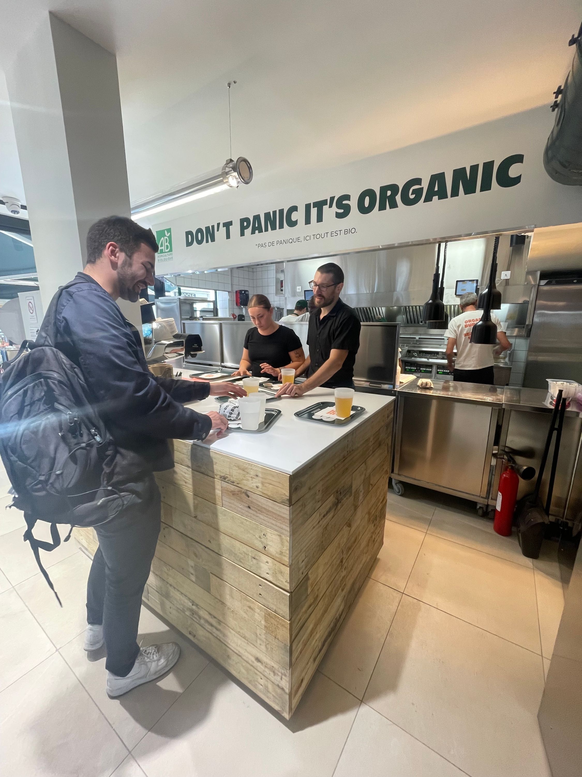 Espace de restauration avec un comptoir servant des burgers bio et options végétariennes.