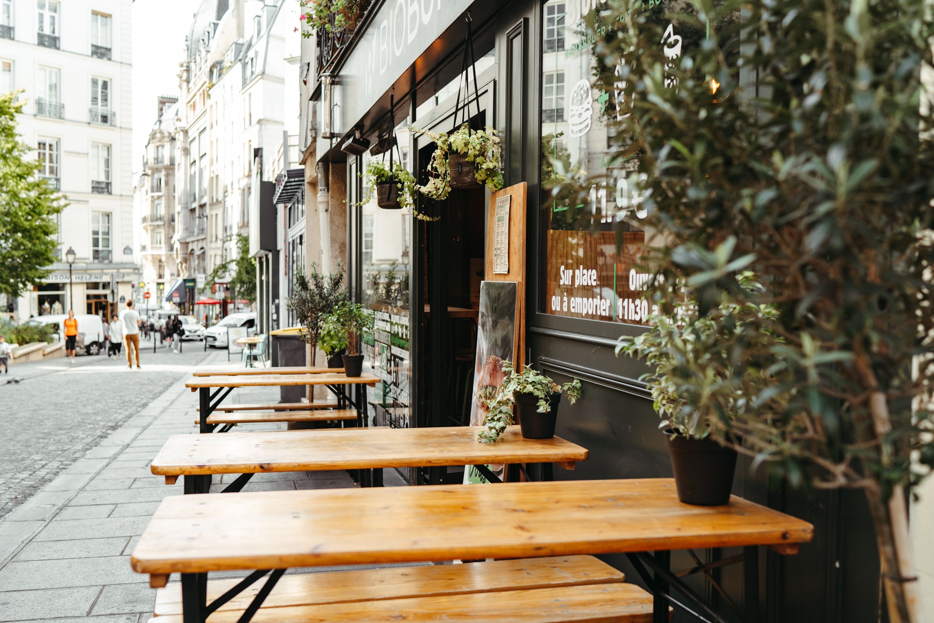 Terrasse en bois du restaurant Bioburger Montorgueil, avec des plantes et un ambiance conviviale en ville.