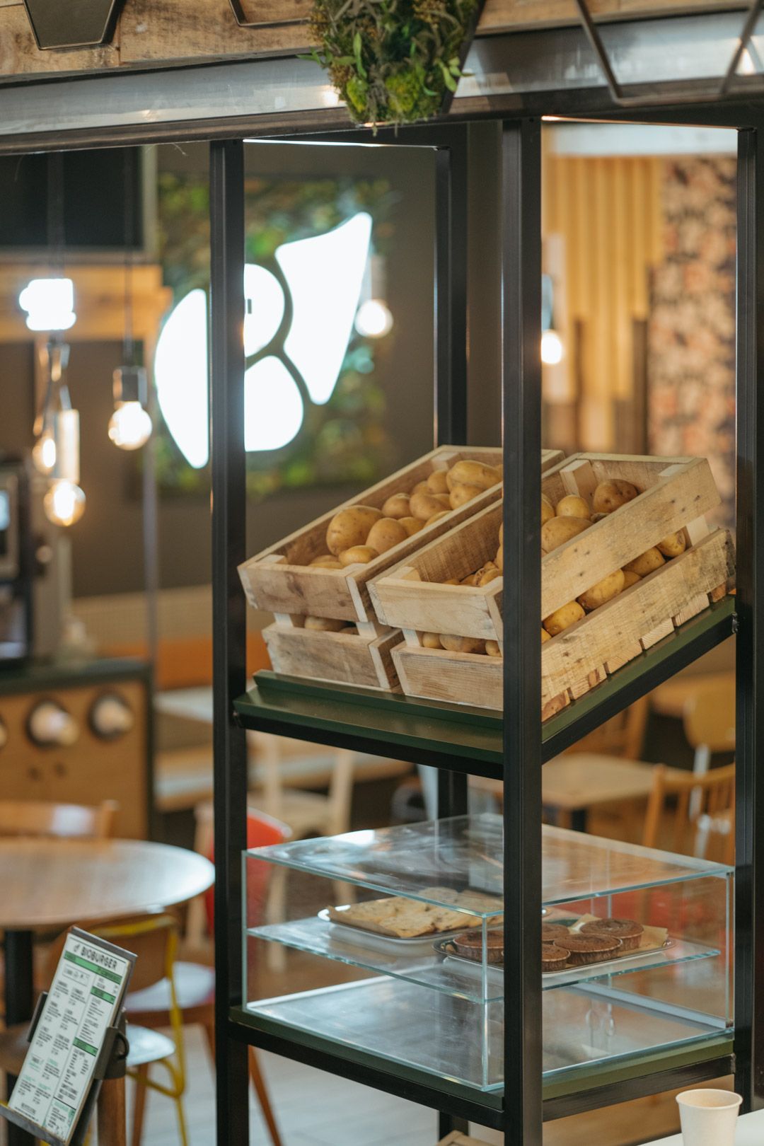 Espace intérieur de Bioburger Lyon Part-Dieu avec des caisses de pommes de terre et des installations pour les burgers.