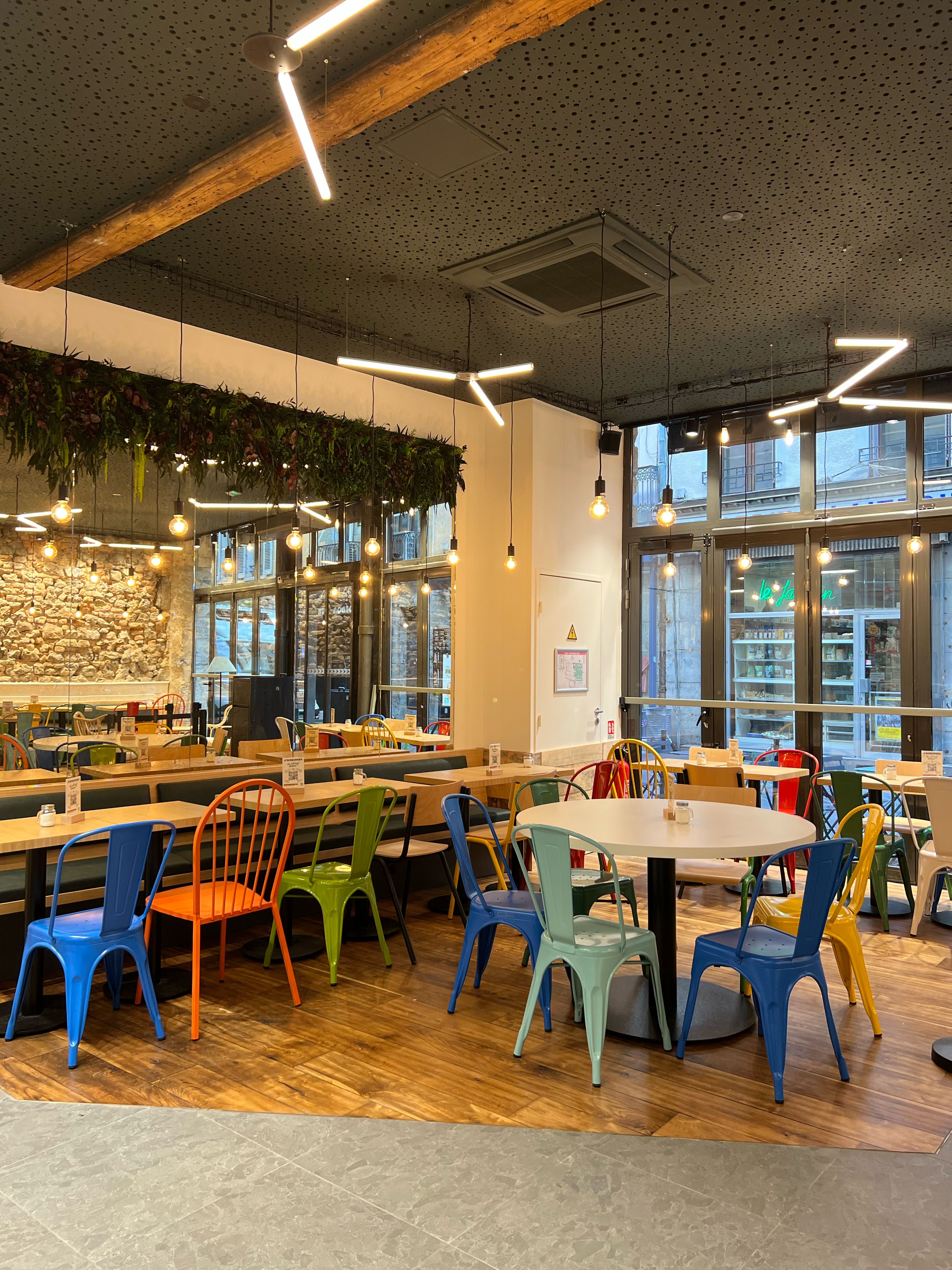 Un intérieur moderne et coloré du restaurant avec des tables et des chaises, offrant une ambiance accueillante.