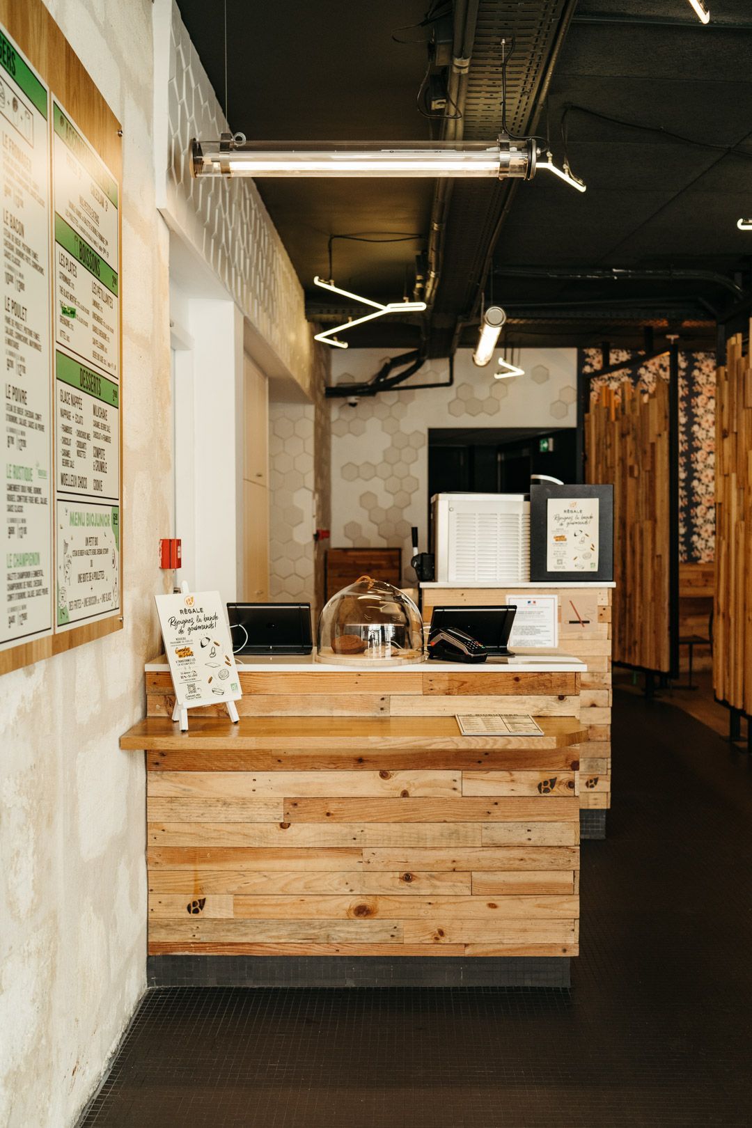 Espace de commande en bois, avec des menus affichés et un comptoir accueillant au Bioburger Bordeaux Gambetta.