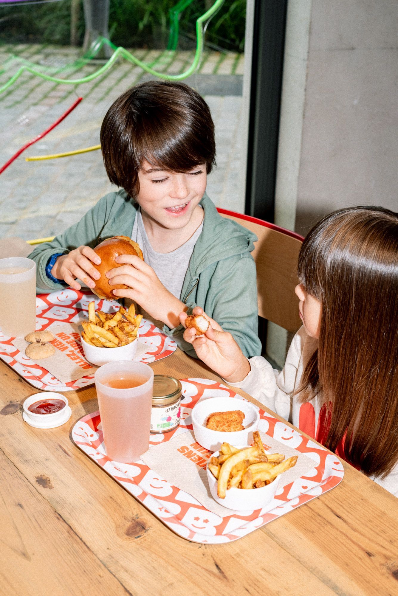 Repas composé de burgers, frites et boissons, idéal pour un repas bio et végétarien.
