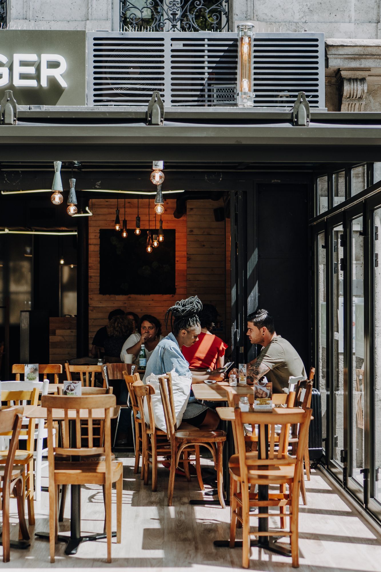 Espace accueillant avec des tables en bois, mettant en avant une ambiance conviviale pour savourer des burgers bio.