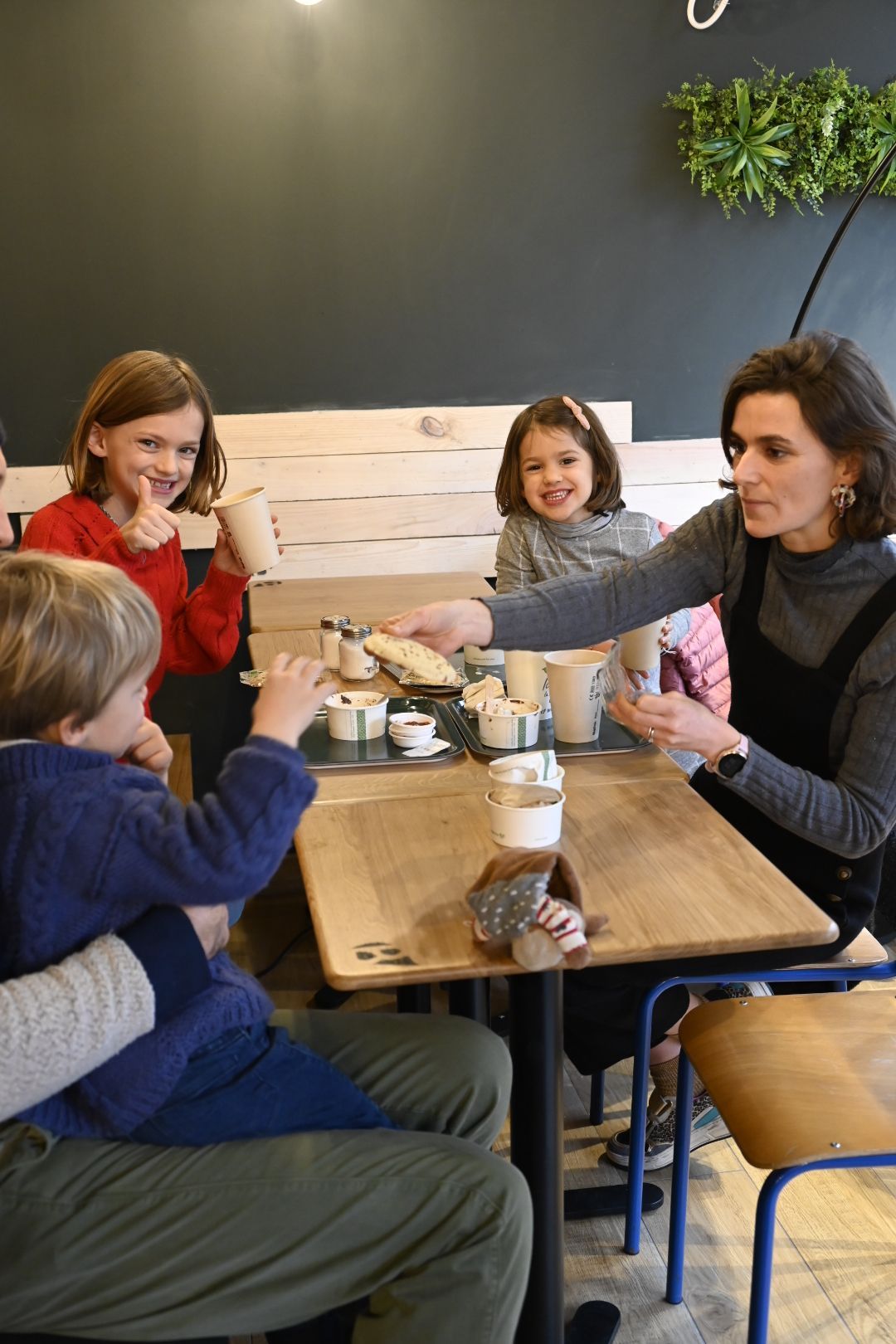 Un moment convivial au restaurant, avec des enfants partageant des burgers végétariens dans une ambiance chaleureuse.