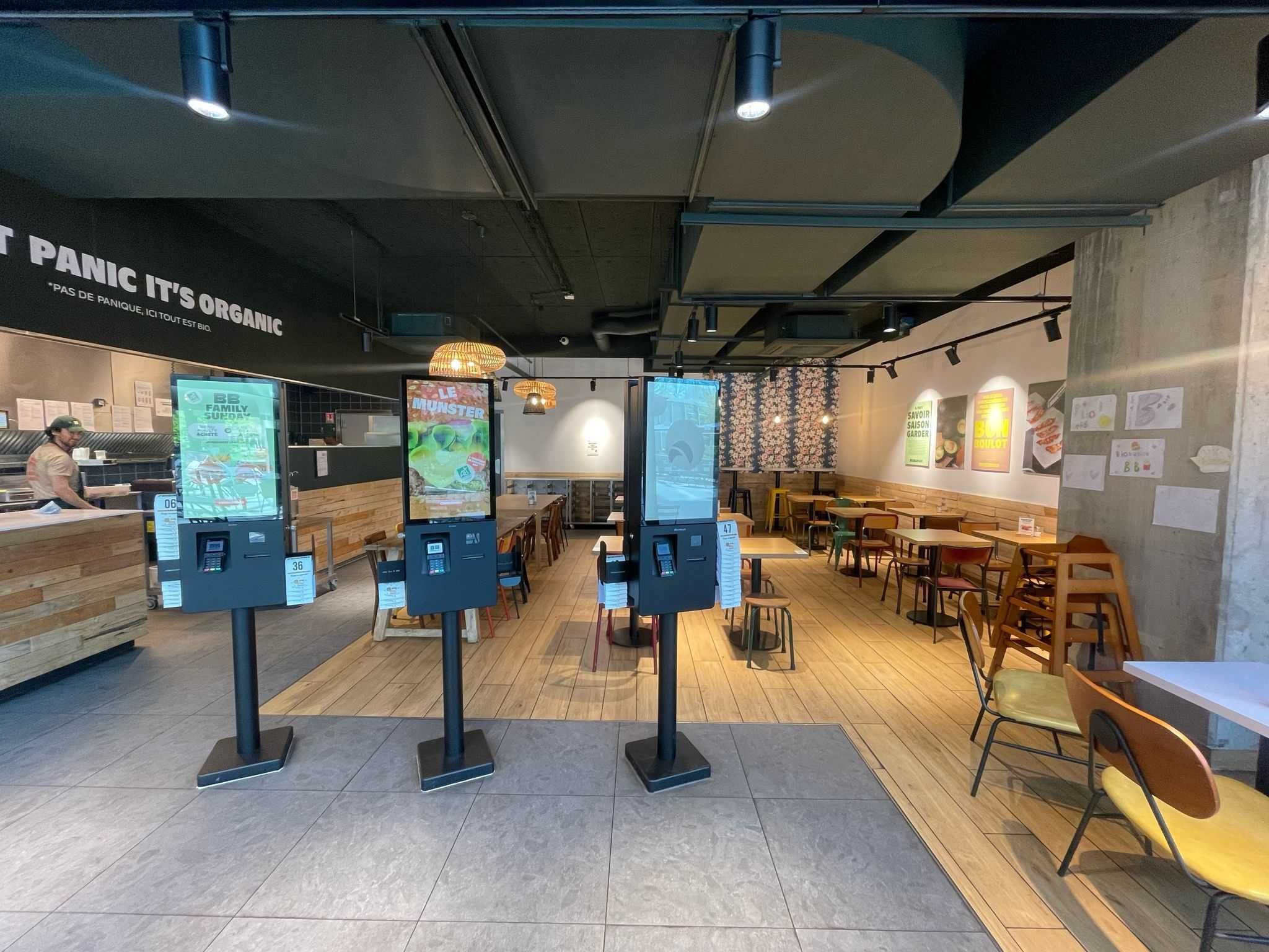 Espace intérieur de Bioburger Wacken avec des bornes de commande et un décor moderne."