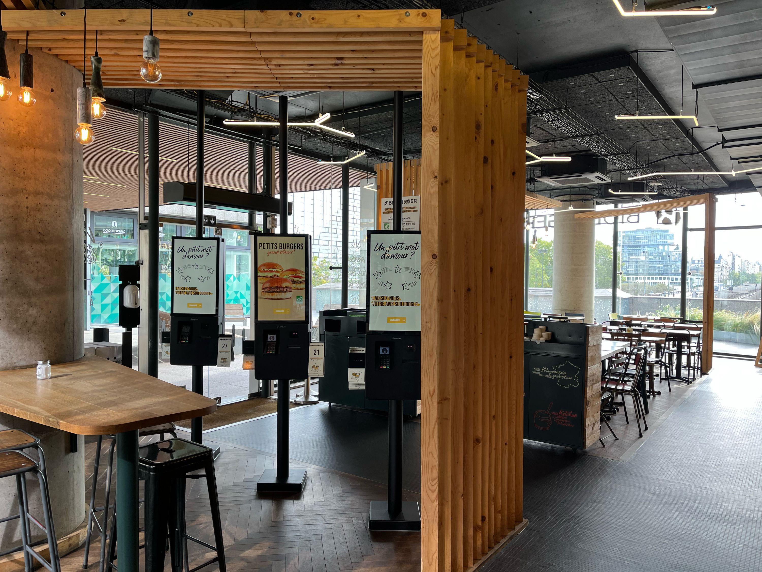 Espace intérieur moderne du restaurant Bioburger Oxygen avec bornes de commande et tabourets.