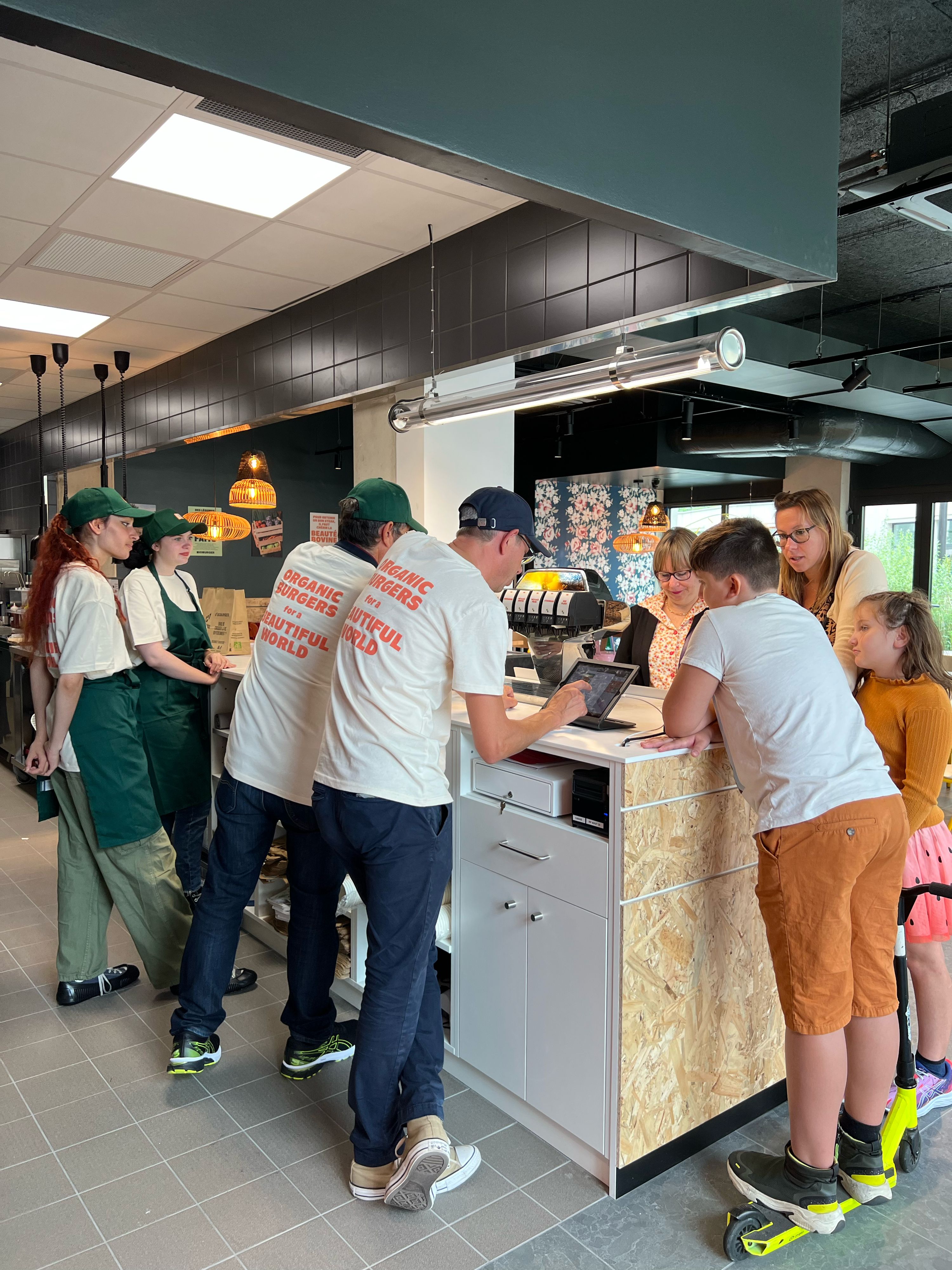 Clients commandent dans le restaurant Bioburger, mettant en avant des options bio, végétariennes et véganes.